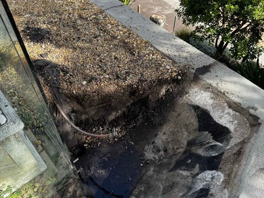Compact excavated opening beside paving with wet soil