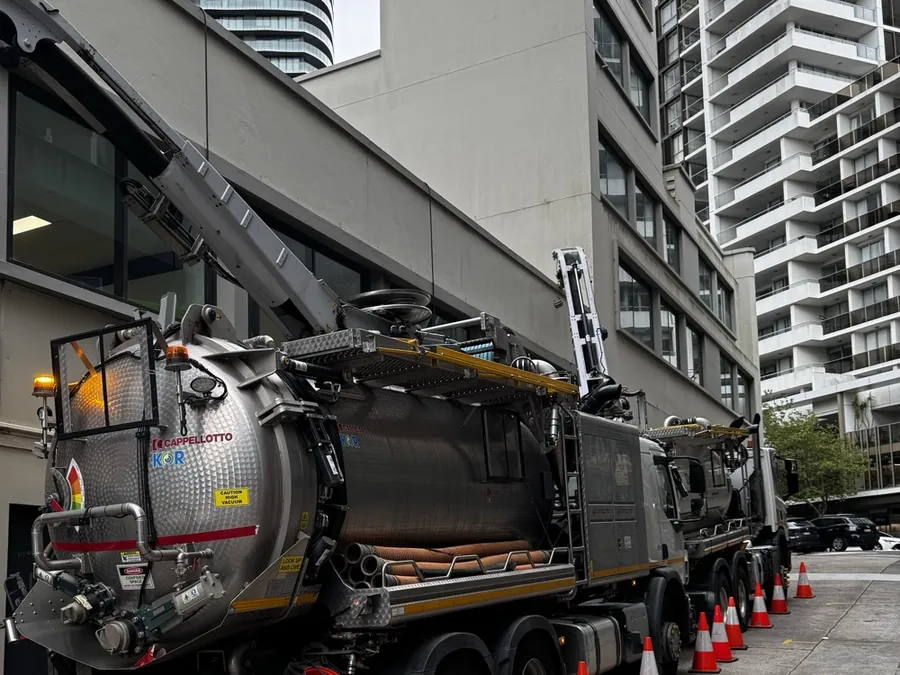 Vacuum truck beside multi-unit buildings