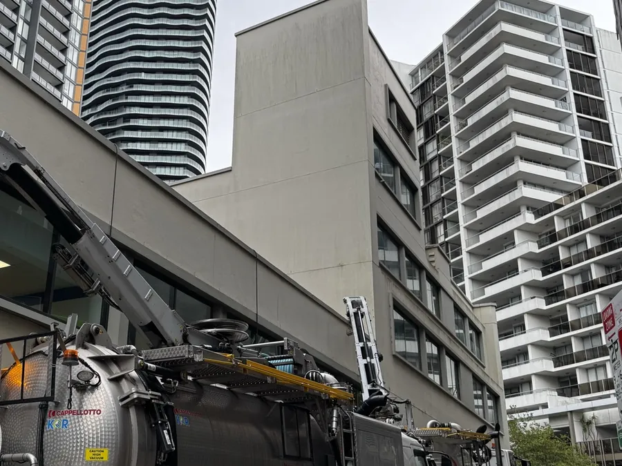 Vacuum truck beside an urban building
